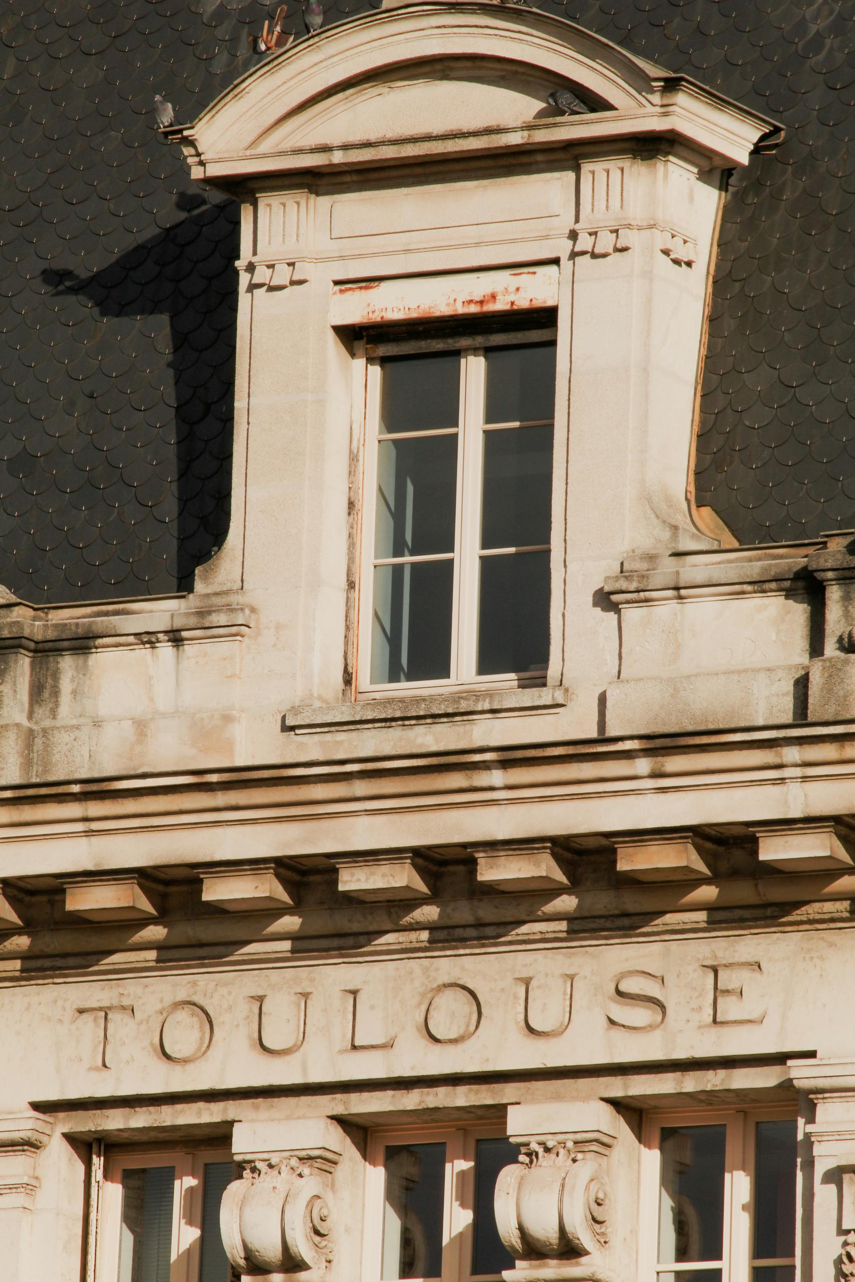 Close-up of ornate architectural details on a historic building in Toulouse, France.